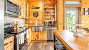 Una cocina con armarios de madera, electrodomésticos de acero inoxidable y encimera de madera.