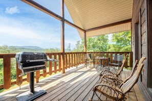 A wooden deck with a grill, chairs, and a view of the landscape. - Awesome View (Sevierville)