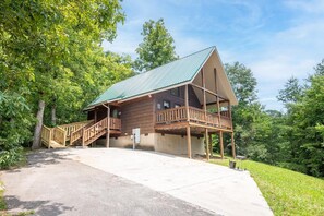 A wooden cabin with a balcony, a staircase, and a paved driveway. - Awesome View (Sevierville)