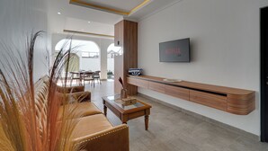 Una sala de estar moderna con sofá, mesa de centro y televisor de montaje con 'NETFLIX'.