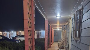 Un espacio al aire libre techado con sillas y un sendero que lleva a un edificio.