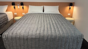 Ein Hotelzimmer mit einem großen Bett, zwei Nachttischen und Wandlampen.