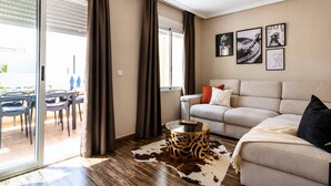 A modern living room with a sofa, a coffee table, and a dining area with chairs and a table. - Pink Harmony Apartment (Torrevieja)