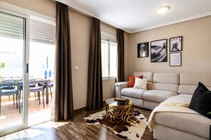 Ein modernes Wohnzimmer mit Sofa, Couchtisch und Essbereich mit Stühlen und Tisch.