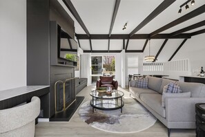 A modern living room with a sofa, coffee table, and a fireplace. - Lakeview Luxury Retreat | Stunning Views | Walk to Queenstown (Queenstown)