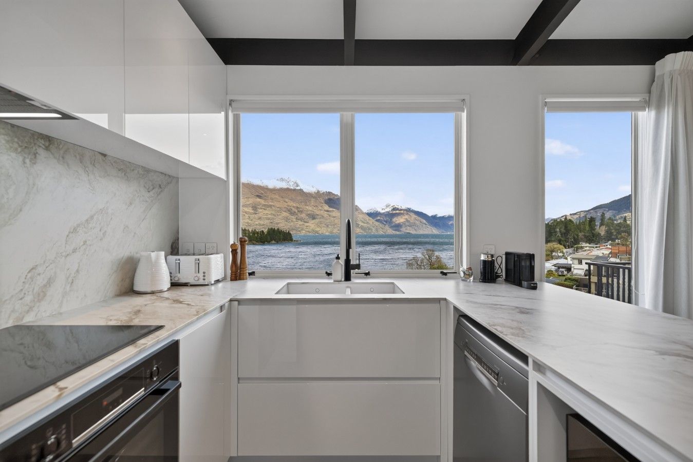 Une cuisine moderne avec vue sur un lac et des montagnes.