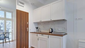Una cocina moderna con armarios blancos, salpicadero de mármol y encimera de madera.