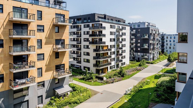 Een meerlaags woongebouw met balkons, een centrale binnentuin en een modern architectonisch ontwerp.