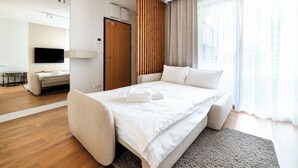 Een moderne hotelkamer met een groot bed, een televisie, een bureau en een kledingkast.