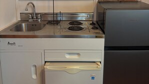 Une cuisine équipée d’une cuisinière, d’un évier et d’un réfrigérateur.