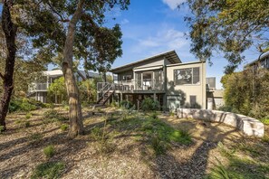 A modern two-story house with a deck, surrounded by trees and a landscaped garden. - Stunning Roadknight Residence (Anglesea)