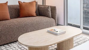 Una sala de estar moderna con un sofá, una mesa redonda de centro y una lámpara de pie.