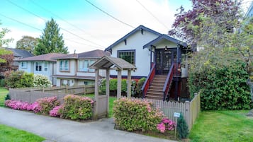 A two-story house with a covered porch and a staircase leading to the entrance.