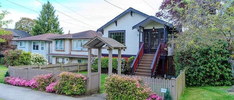 A two-story house with a covered porch and a staircase leading to the entrance.