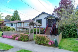 A two-story house with a covered porch and a staircase leading to the entrance.