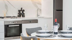 Una cocina moderna con comedor, una botella de vino y una botella de vino tinto.