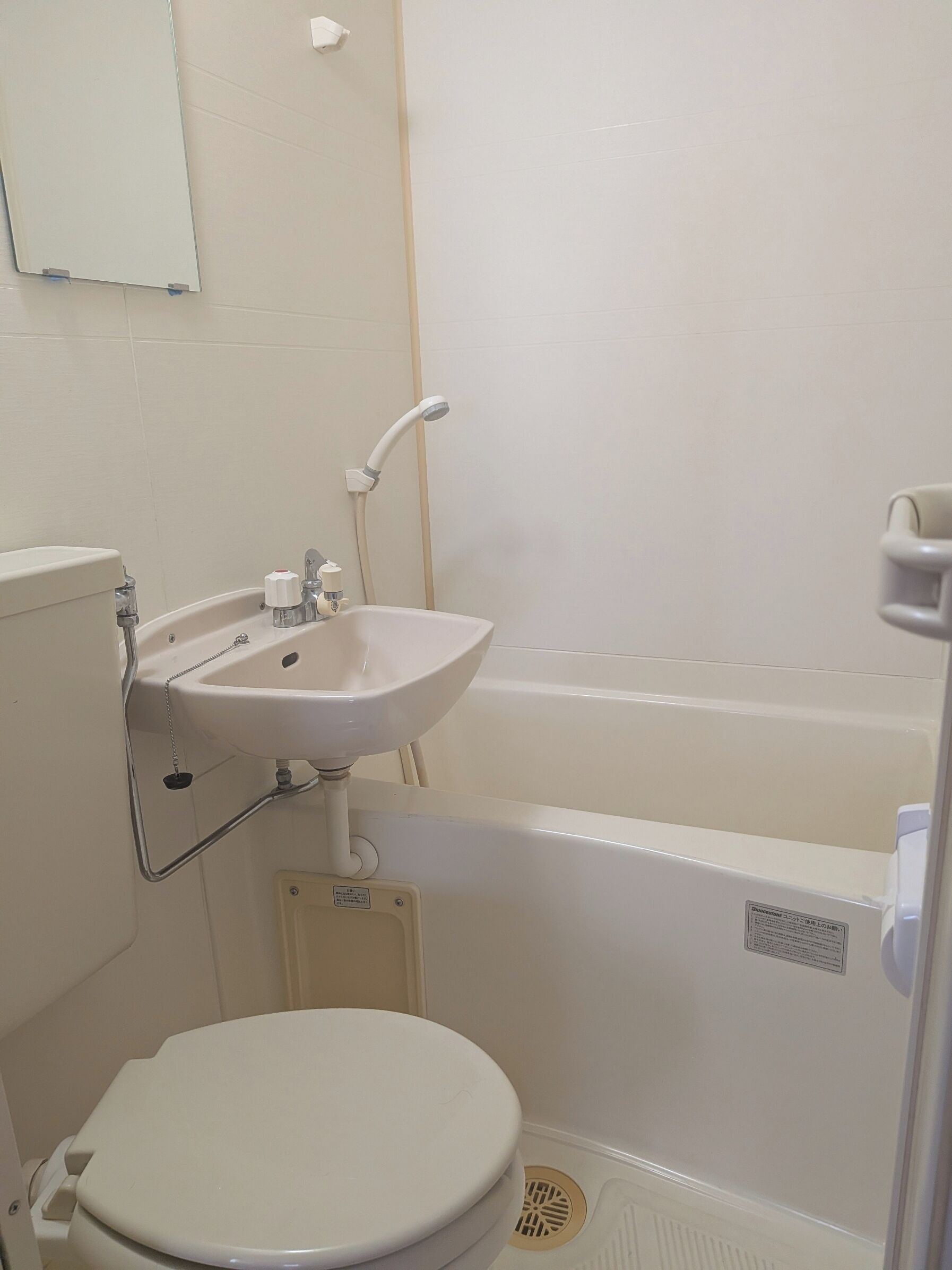 A bathroom with a toilet, sink, and bathtub.