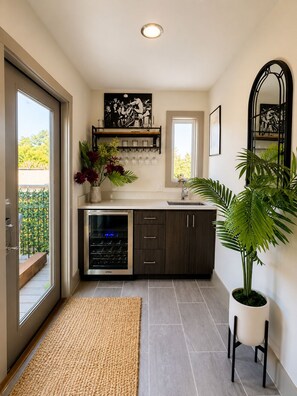 A modern kitchen with a built-in oven, dark wooden cabinets, and a large potted plant. - Luxe ATL Rooftop Retreat/Walking Distance Beltline/9 mins from Mercedes Benz (Atlanta)