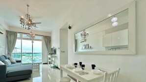 Una sala de estar moderna con sofá, mesa de comedor, sillas y un ventanal con vistas.