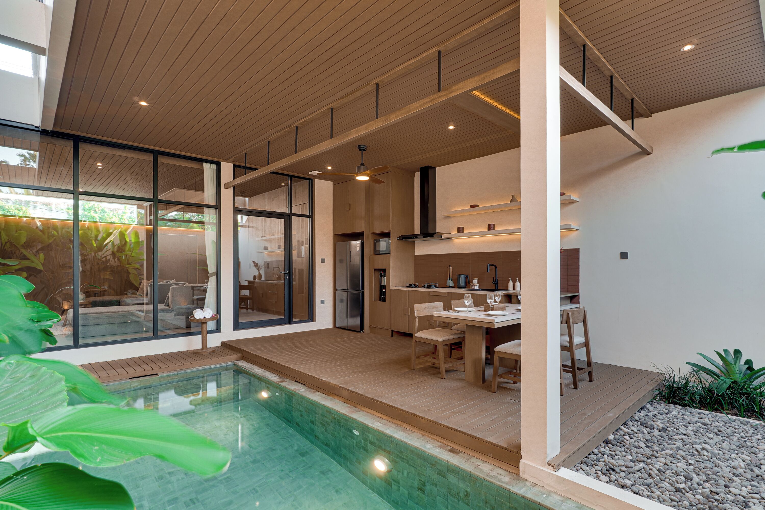 A modern kitchen with a dining area, a pool, and a view of the outdoors.