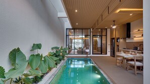 Ein moderner Poolbereich innen, mit Essbereich und Küche.