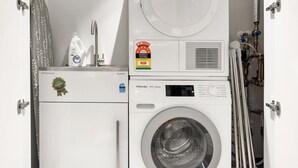 En kompakt tvättmaskin och torktumlare i en enhet, utrustad med en tydlig energimärkning, en kontrollpanel och en vattenvärmare.