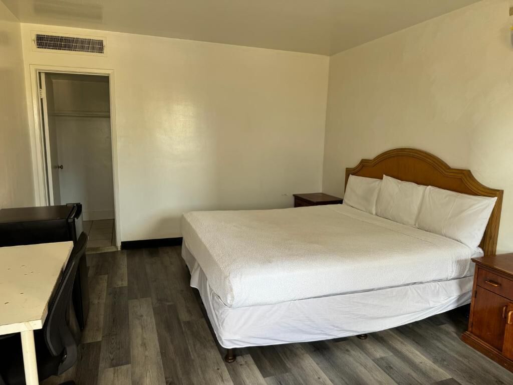 A room with a bed, a desk, and a wardrobe.