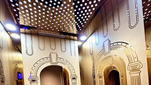 A modern interior with a staircase, decorative ceiling, and architectural elements.