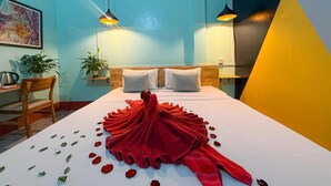 A hotel room with a bed, two bedside lamps, a desk, a chair, and two potted plants. - Social Backpacker Hostel & Rooftop Bar (Battambang)