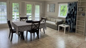 Un coin repas comprenant une table et des chaises, un canapé, une petite table et une bibliothèque.