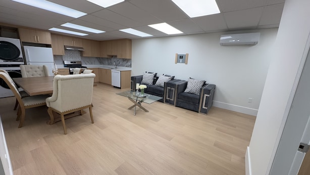 A modern kitchen with a dining area, a sofa, and a glass coffee table. - Entire condo in White Rock, Canada (White Rock)