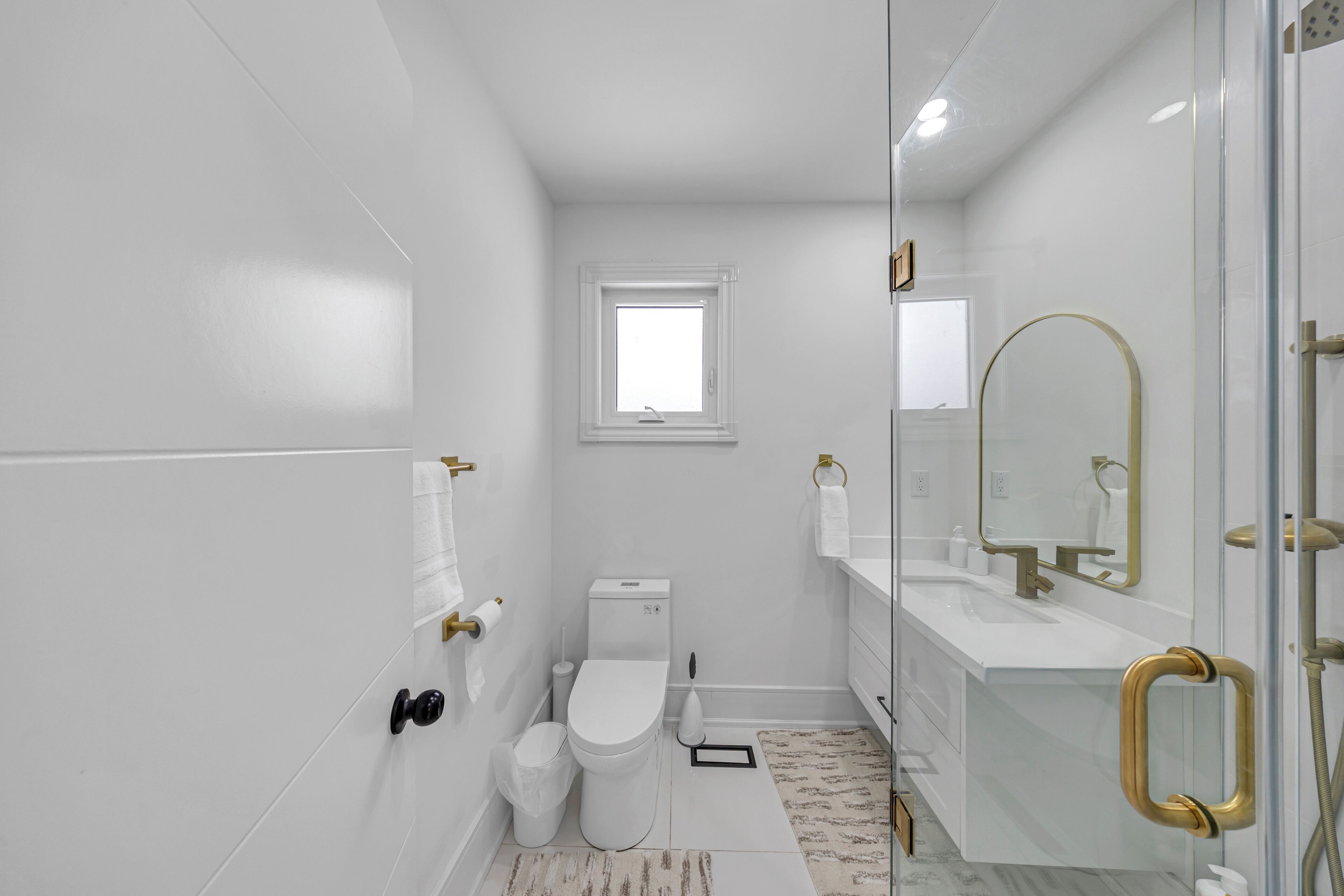 Un baño moderno con inodoro, lavamanos y ducha.