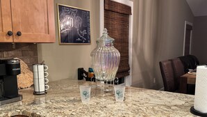 Eine Küche mit einer Kaffeemaschine, einem Glasbehälter und zwei Starbucks-Tassen auf der Arbeitsfläche.