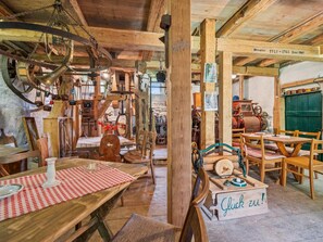A rustic interior with wooden furniture, a table with a checkered tablecloth, and various antique items. - Rustic home near farmhouse in the South Harz (Sangerhausen)