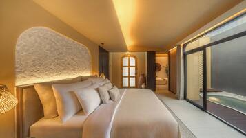 Habitación de hotel moderna con una cama grande, vista al océano y una pared con textura original.