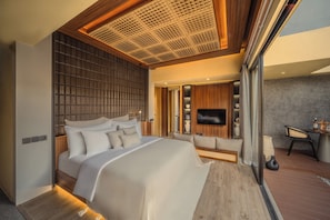 A modern bedroom with a large bed, a TV, and a seating area. - Leedon Villa Seminyak by Ini Vie Hospitality (Kuta Utara, Badung)