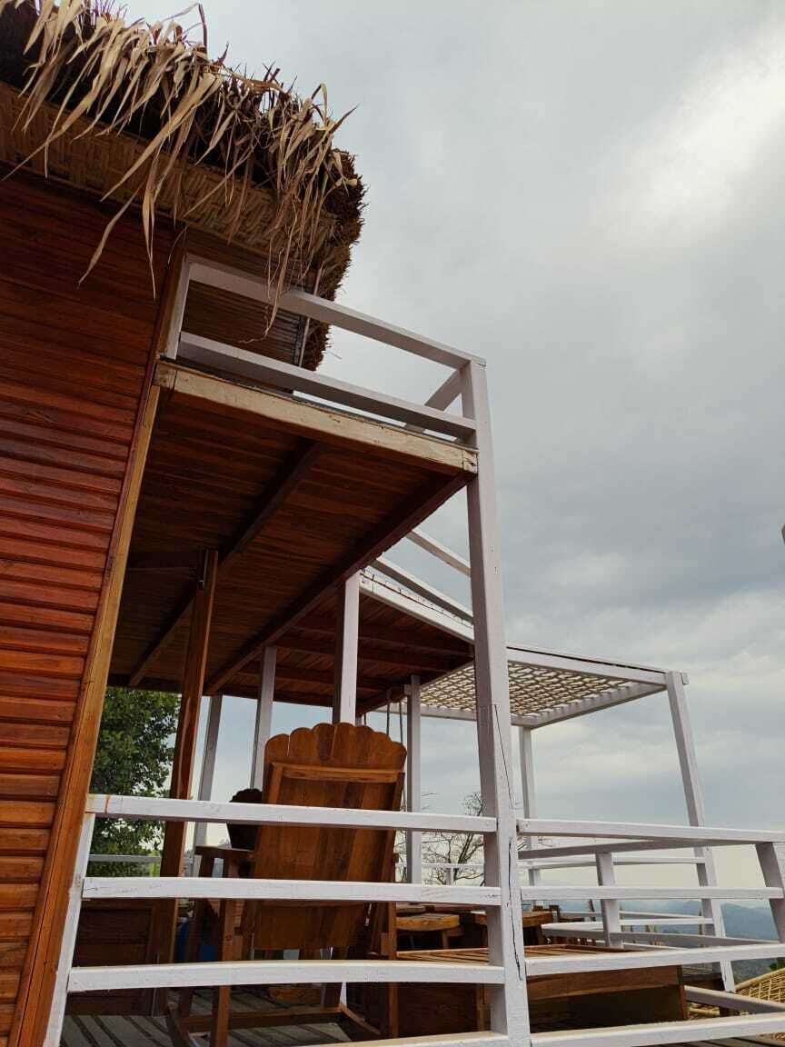 Ein Gebäude aus Holz mit einem Strohdach, einer weißen Metalltreppe und Blick zum Himmel.