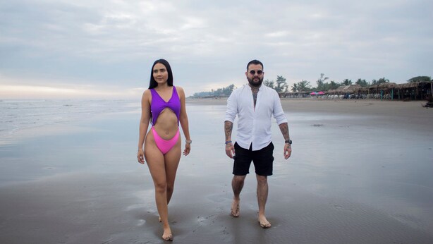 A beach with a couple walking.