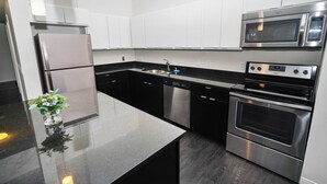 A modern kitchen with stainless steel appliances, a dishwasher, and a microwave.