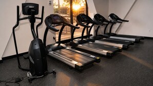 A gym with treadmills, a stationary bike, and a rowing machine.