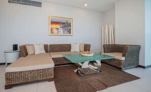 A modern living room with a sectional sofa, a glass coffee table, and a painting on the wall. - Corporate Stays Miami (Asunción)