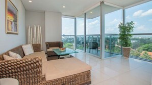 A modern living room with a sofa, a glass coffee table, and a view of a cityscape through large windows. - Corporate Stays Miami (Asunción)