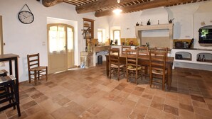 Una cocina rústica con comedor, un reloj y una chimenea.