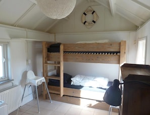 A bunk bed room with a ladder, a small table, and a chair. - Bungalow Near Dishoek Beach (Koudekerke)