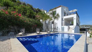 Eine moderne Villa mit Swimmingpool, Balkon und Blick auf die umliegende Landschaft.