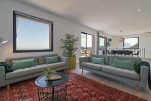 A modern living room with two grey sofas, a red patterned rug, and a large window. - Casa Zoe 6 pax - Pedreguer, Costa Blanca (Pedreguer)