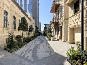 A street lined with buildings, some with balconies and others with large windows.