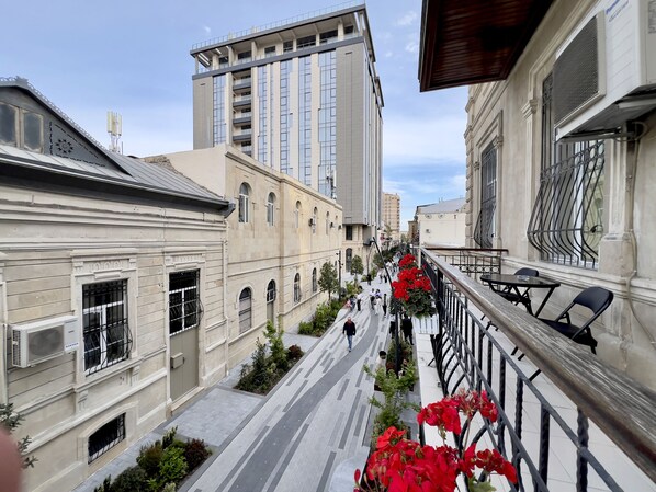 A narrow street flanked by buildings with balconies and a pedestrian walkway.