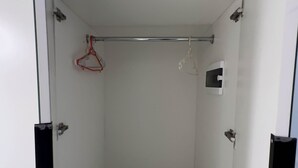 A room with a basketball hoop, a small window, and a door.