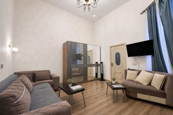 Bright living area with seating, TV, storage, and high ceilings